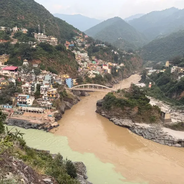 The confluence of the green Bhagirathi and the brown Alaknanda at Devprayag, with houses climbing the hillside