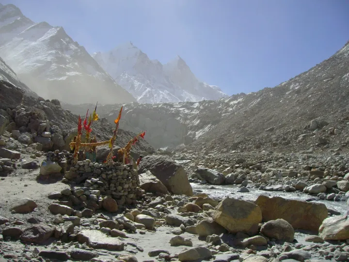 A small shrine with colourful flags at Gaumukh, the snout of the Gangotri Glacier, with the Bhagirathi peaks behind