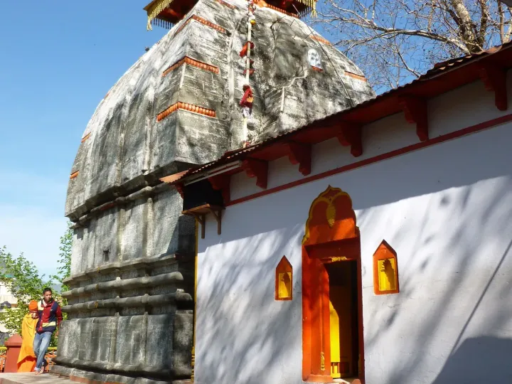 The stone shikhara of the Kashi Vishwanath temple in Uttarkashi with a yellow flag